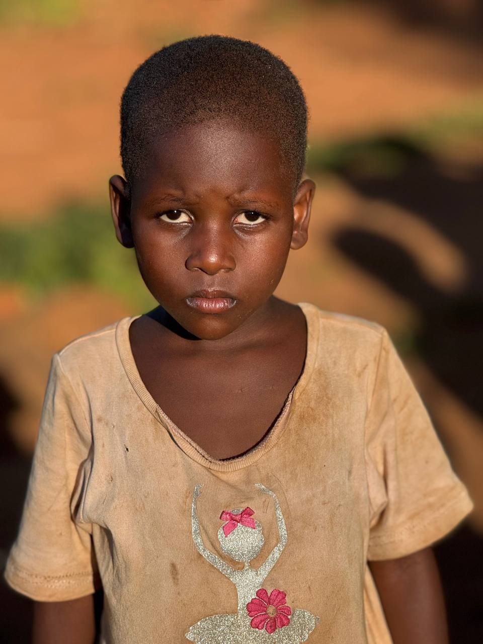 A sponsored child smiling with a caregiver